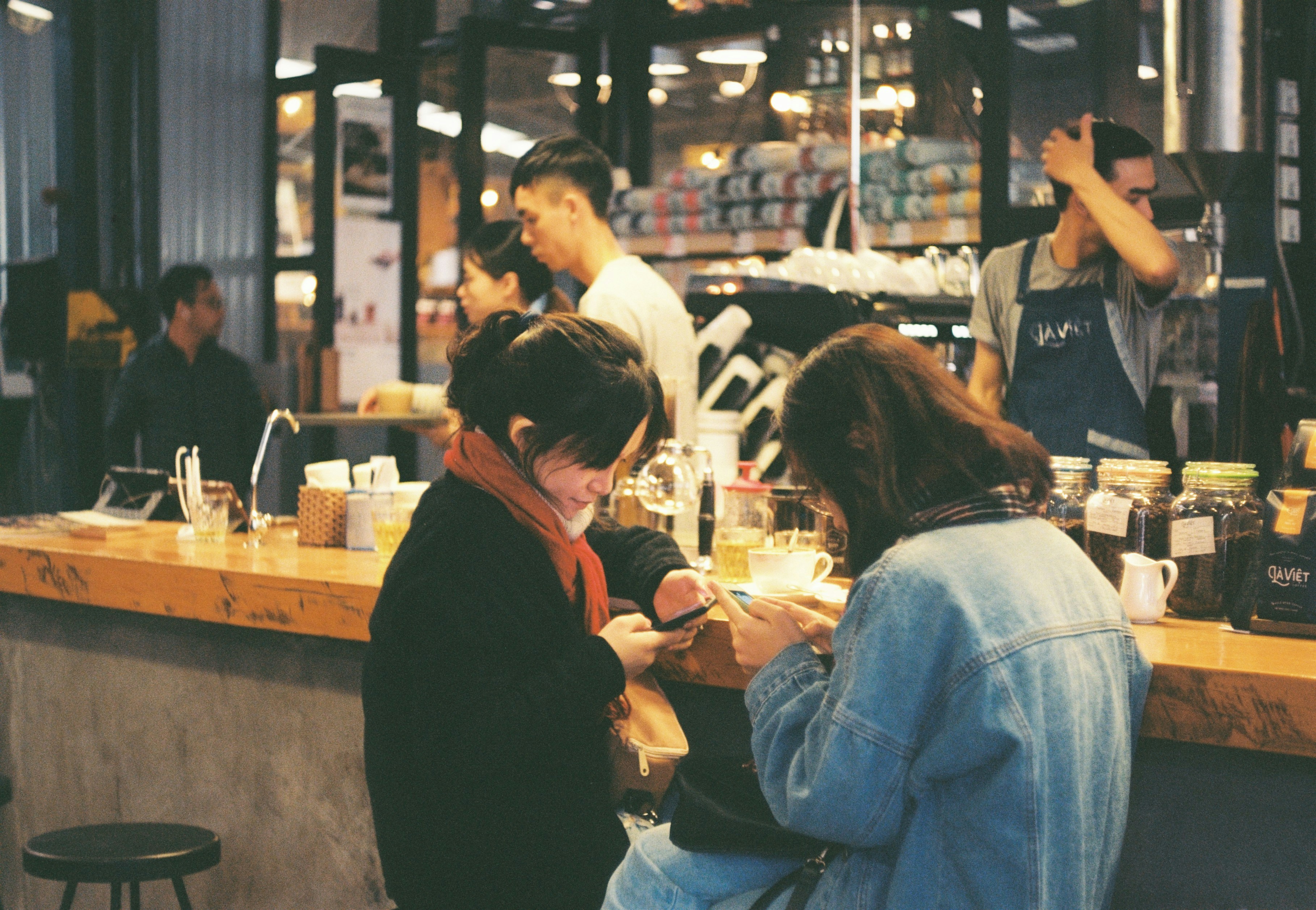 Two women hunched over on their phones